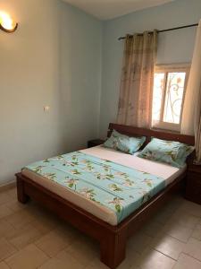 - une chambre avec un grand lit et une fenêtre dans l'établissement Résidence Allégra, à Yaoundé