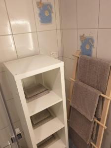 um armário branco na casa de banho com toalhas em Monteurwohnung Matthias Apelrath Solingen em Solingen