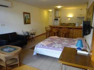 a room with a bed and a table and a kitchen at Fare Arearea Sweet Studio in Papeete +2 photos