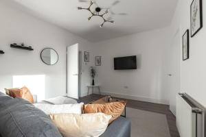 ein Wohnzimmer mit einem Sofa und einem TV in der Unterkunft Beautiful 4 bedroom house in Reading