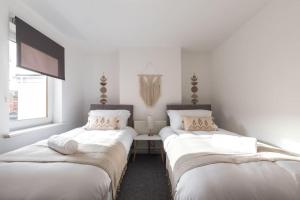 2 Betten in einem Zimmer mit weißen Wänden in der Unterkunft Beautiful 4 bedroom house in Reading
