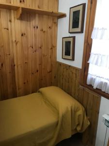 a bedroom with a bed in a room with wooden walls at appartamento incantevole con camino in Rocca di Mezzo