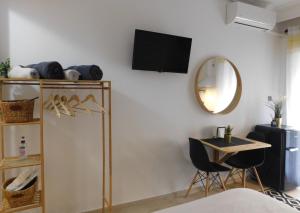 a room with a tv and a table and a mirror at Brand New Studio 1 in Komotini