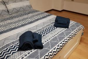 Una cama con dos pares de calcetines y zapatos. en Vicino a Sant'Orsola e centro città, silenzioso e accogliente, en Bolonia