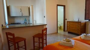 a kitchen with a counter and two stools in a room at Porta Nuova Room Locazione Breve Turistica in Benevento