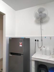 a kitchen with a refrigerator and a fan at Abie's Homestay Putrajaya in Putrajaya