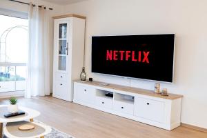 a living room with a television on a white wall at INhome: Garten - Terrasse - Parkplatz - Netflix in Kirchberg an der Jagst