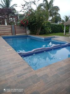 a swimming pool with a hose in a yard at Villa kosniin in Tecolutla