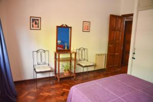 a bedroom with two chairs and a mirror at Casabunda Multiespacio, habitación privada en el centro in Salta