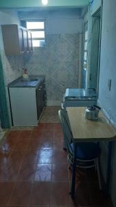 a small kitchen with a table and a sink at Pousada da Amália in Cidreira