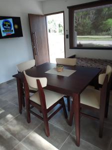 a dining room table and chairs with a window at Casa Moderna in Mina Clavero