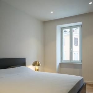 sypialnia z białym łóżkiem i oknem w obiekcie Luxury Apartment Contesa w Rovinj