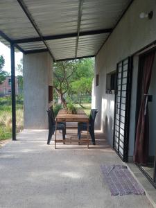 un patio con mesa de madera y sillas en Casa Moderna en Mina Clavero