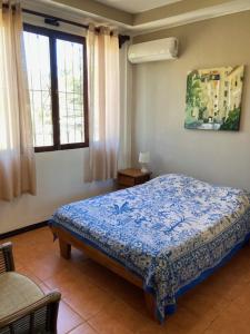 a bedroom with a bed in a room with windows at Casa Sueno Colibri in Tamarindo