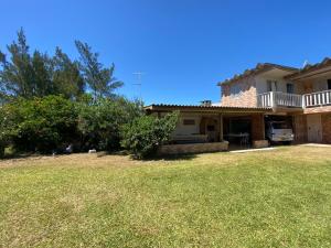 a house with a yard in front of it at Pousada da Amália in Cidreira