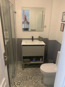 a man taking a picture of a bathroom with a toilet and sink at acogedor apartamento 2 dormitorios in Granada