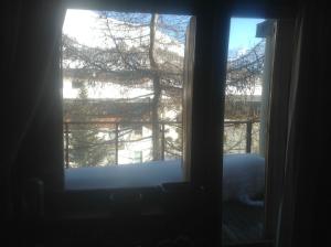 an open window with a view of a tree at Casa Glesia in Sestriere