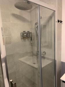 y baño con ducha y puerta de cristal. en acogedor apartamento 2 dormitorios, en Granada