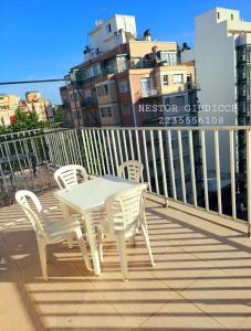 - Balcón con mesa blanca y sillas en Alsina 2300 Depto 2 ambientes con terraza propia en Mar del Plata