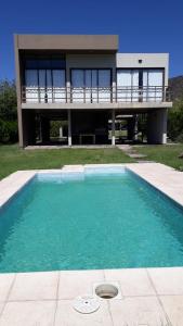 a house with a swimming pool in front of a house at Chalet en Valle Grande - En Solar del Valle Country Club in Valle Grande