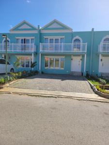 una casa azul con un coche aparcado delante de ella en Brand New Luxurious Townhouse in Negril, en Negril