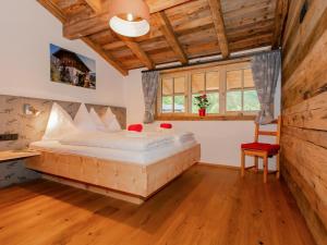 um quarto com uma cama grande num quarto com tectos em madeira em Das Rendlgut Top 5 em Lofer