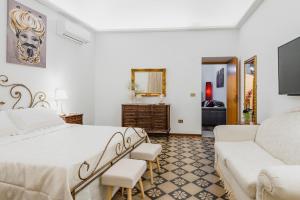 a white bedroom with a bed and a couch at centro, stile siciliano, balconi e terrazzino interno parcheggio Alfycodindia in Catania