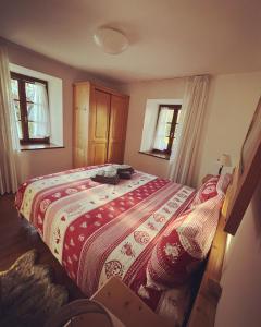 sypialnia z dużym łóżkiem i czerwonym kocem w obiekcie DOLOMITI HOUSE STUBE w mieście Fiera di Primiero