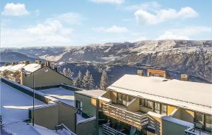 a building with snow covered roofs and mountains in the background at Stunning Apartment In Vason With Kitchen in Vason