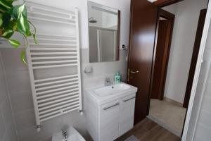 Baño blanco con lavabo y espejo en Casa Pietro e Bea, en Rapallo