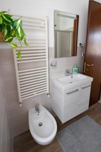 La salle de bains blanche est pourvue de toilettes et d'un lavabo. dans l'établissement Casa Pietro e Bea, à Rapallo