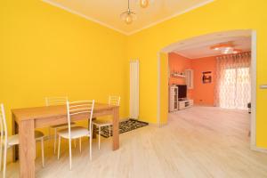 a dining room with a wooden table and yellow walls at Il Ciclamino in Tarquinia