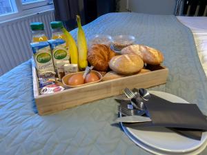 ein Tablett mit Brot und anderen Speisen auf dem Tisch in der Unterkunft Hotel de Slapende Hollander in Kaatsheuvel