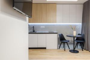 Una cocina con una mesa y dos sillas y un fregadero. en InshiApartments on Kulisha str, en Leópolis 51 fotos más