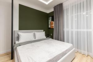 een slaapkamer met een wit bed en een groene muur bij InshiApartments on Kulisha str in Lviv