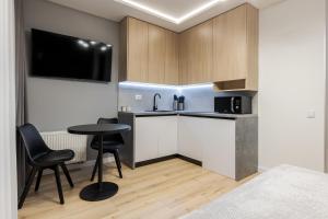 Una pequeña cocina con una mesa y un microondas. en InshiApartments on Kulisha str, en Leópolis