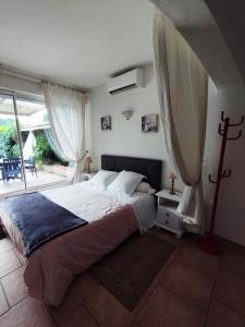 a bedroom with a large bed and a balcony at AU VALLON ROUGE (Studio) in Saint-Paul-de-Vence