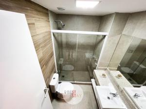 uma casa de banho com um chuveiro, um WC e um lavatório. em Condomínio Pratik no Jardim Botânico no Rio de Janeiro