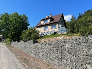 ein Haus auf einer Steinmauer in der Unterkunft Přízemí rodinného domu in Košťálov
