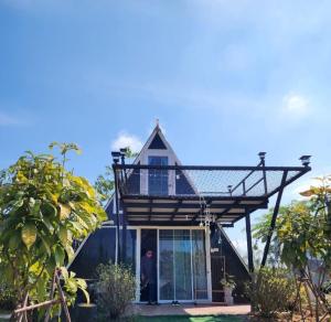 a house with a gambrel roof with a balcony at บ้าน วังน้ำเขียว in Ban Kom