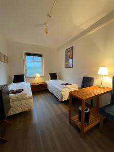 um quarto com 2 camas, uma mesa e uma secretária em Otel Vaabensted em Sakskøbing