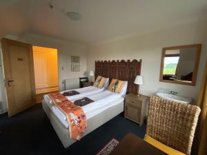 SakskøbingOtel Vaabensted的带床、水槽和镜子的卧室