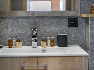 a counter with bottles of essential oils on a sink at Appartement Courchevel 1650, 4 pièces, 6 personnes - FR-1-563-36 in Courchevel