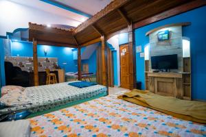 1 dormitorio con 2 camas y TV. en Godwill Casa Varca en Varca