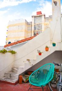 una silla azul sentada frente a una escalera en Casabunda Multiespacio, habitación privada en el centro en Salta