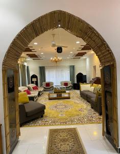 an archway in a living room with couches and tables at Aryaf hostel in Nizwa