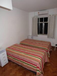 1 dormitorio con 1 cama con manta a rayas en Apartment in Rio with parking, en Río de Janeiro