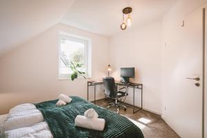 a bedroom with a bed and a desk and a window at Ferienhaus in Lübeck ruhig mit Garten, Terrasse, Parkplatz, für 7 Personen in Lübeck