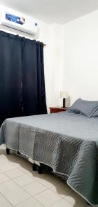 Un dormitorio con una cama con una manta. en DEPTO CENTRO SALTA. DEAN FUNES 45 en Salta