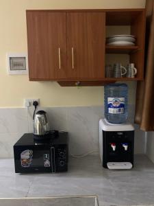 cocina con microondas y cafetera en Mtwapa Apartment en Mombasa